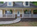 Close-up of the cozy front porch with decorative plants and charming architectural details at 420 Bear Cub Path, Social Circle, GA 30025