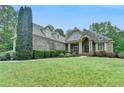 Stately brick home with a well-manicured lawn and mature landscaping at 5195 Stefan Ridge Way, Buford, GA 30519