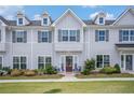 Inviting townhome with well-maintained landscaping, gray siding, dark shutters, and a vibrant red door at 1702 Prospect Way, Conyers, GA 30094