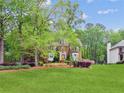 Traditional brick home with lush green lawn, mature trees, and well-maintained landscaping at 22 Oakwood Hills Dr, Suwanee, GA 30024