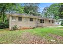 Side view of home featuring brick exterior and green lawn at 3367 Misty Valley Rd, Decatur, GA 30032