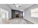 Bright living room features a stone fireplace and modern gray flooring at 6801 Red Maple Dr, Rex, GA 30273