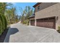 Spacious driveway featuring access to the garage, bordered by natural landscaping at 140 Johnson Rd, Suwanee, GA 30024
