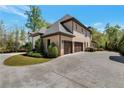 Wide driveway leading to a three-car garage, set against a backdrop of mature trees at 140 Johnson Rd, Suwanee, GA 30024
