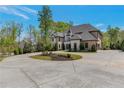 Beautiful two-story home with a circular driveway surrounded by lush greenery at 140 Johnson Rd, Suwanee, GA 30024