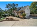 A brick house with black shutters sits on a beautifully landscaped lawn at 180 Spring Ridge Trace, Roswell, GA 30076
