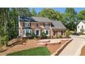 Traditional brick home featuring manicured landscaping and a curved driveway at 180 Spring Ridge Trace, Roswell, GA 30076