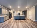 Spacious kitchen showcasing an island, gray cabinets, stainless steel appliances, and hardwood floors at 2458 Morgan Creek Rd, Buford, GA 30519