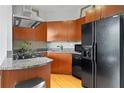 Well-lit kitchen with granite countertops, wood cabinets, and stainless steel appliances at 2626 Peachtree Nw Rd # 606, Atlanta, GA 30305