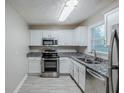 Modern kitchen features stainless steel appliances, granite countertops, white cabinets, and tiled floors at 2796 Green Trail Dr, Atlanta, GA 30349