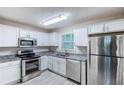 Bright kitchen with stainless steel appliances, granite countertops, white cabinets, and tiled floors at 2796 Green Trail Dr, Atlanta, GA 30349