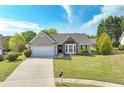 Inviting one-story home featuring a well-manicured lawn, brick accents, bay window, and a convenient two-car garage at 2602 Midler Ct, Buford, GA 30519