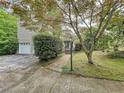 Home exterior featuring mature trees, attached garage, and a walkway to the front door at 3220 Stoney Acres Nw Dr, Kennesaw, GA 30152