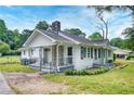 This home features a white exterior, stone chimney, covered porches, and a well-maintained yard at 1236 Stone Mountain Lithonia Rd, Lithonia, GA 30058