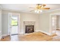 Living room with hardwood floors, a stone fireplace, ceiling fan and natural light streaming through the windows at 1236 Stone Mountain Lithonia Rd, Lithonia, GA 30058