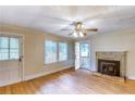 Bright living room featuring hardwood floors, a stone fireplace, and a ceiling fan at 1236 Stone Mountain Lithonia Rd, Lithonia, GA 30058