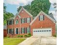 Charming two-story brick home with a well-manicured lawn and a two-car garage in a suburban neighborhood at 1485 Oglethorpe Run Ln, Suwanee, GA 30024