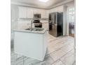 Well-lit kitchen featuring an island sink, granite countertops, stainless steel appliances, and sleek white cabinets at 1485 Oglethorpe Run Ln, Suwanee, GA 30024