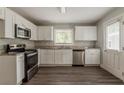 Bright kitchen featuring white cabinets, stainless steel appliances, and wood flooring at 2465 Hogan Rd, Atlanta, GA 30344