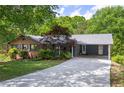 View of the home with a long driveway and a convenient covered parking area at 6857 Womack Ct, Atlanta, GA 30360