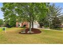 Scenic view of a brick home with an attached garage, nestled on a spacious lot with mature trees at 205 Devon Downs Pl, Alpharetta, GA 30005