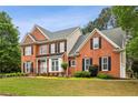 Stately brick residence showcasing a lush front yard and timeless design elements at 205 Devon Downs Pl, Alpharetta, GA 30005