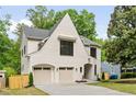 Beautiful home with a white brick facade, two-car garage, arched entryway, and mature trees at 3006 Skyland Ne Dr, Brookhaven, GA 30319