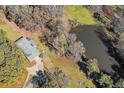 Aerial view of a house with a pond, showcasing its private, wooded surroundings at 574 Oak Grove Rd, Temple, GA 30179