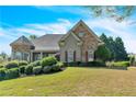Traditional home with a manicured lawn, mature trees, and attractive stone accents on the facade at 147 Gold Bridge Xing, Canton, GA 30114