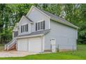 Exterior view showcasing the home's siding, windows with shutters, two-car garage, and a fenced yard at 2326 Westland Way, Acworth, GA 30102
