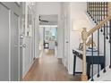 Bright entryway featuring wood floors, staircase with black iron railings, and open access to the kitchen at 286 Abbotts Crossing Cir, Conyers, GA 30094