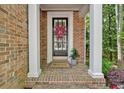 Inviting front porch with brick flooring, decorative wreath, and potted plant at 5407 Waters Edge Trl, Roswell, GA 30075