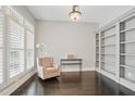 Cozy office featuring custom built-ins, shuttered windows, hardwood floors, and a comfortable chair at 1811 Kent Ave, Dunwoody, GA 30338