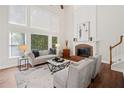 Bright living room with large windows, a cozy fireplace, and hardwood floors at 1880 Barrett Dr, Cumming, GA 30040