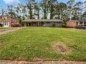 Landscaped front yard of cozy home with gray exterior, carport, and mature shade trees at 3653 Mecklinburg Pl, Decatur, GA 30032