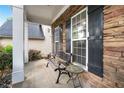 Relaxing front porch area with stone accents, features seating for enjoying the outdoors at 449 Highlands Loop, Woodstock, GA 30188