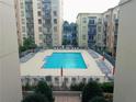 Outdoor pool surrounded by lounge chairs in a multi-story building complex at 711 Cosmopolitan Ne Dr # 123, Atlanta, GA 30324