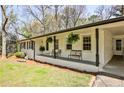 Inviting front porch with seating, hanging plants, and a covered carport area at 1598 Kings Rd, Marietta, GA 30062