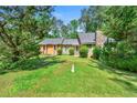 Traditional home showcasing a stone chimney and inviting front yard surrounded by lush trees at 3955 Old Fairburn Sw Rd, Atlanta, GA 30331