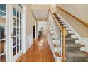 Bright foyer with hardwood floors, staircase, and French doors, creating an inviting entrance at 4560 Weathervane Dr, Alpharetta, GA 30022