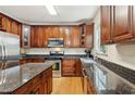 Well-equipped kitchen with rich wood cabinets, granite countertops, and stainless steel appliances at 4560 Weathervane Dr, Alpharetta, GA 30022