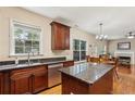 Bright kitchen featuring granite counters, stainless steel appliances, island, and adjacent dining area at 4560 Weathervane Dr, Alpharetta, GA 30022