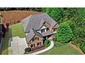 Charming brick home featuring a well-manicured lawn, mature trees, and a long driveway at 1168 Woodtrace Ln, Auburn, GA 30011