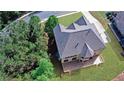 Aerial view of home's backyard featuring an expansive deck, grassy area, and mature trees at 1168 Woodtrace Ln, Auburn, GA 30011