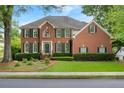 Charming brick house with dark green shutters and a green lawn on a sunny day at 400 Fieldstone Lndg, Alpharetta, GA 30005