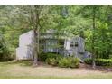 Two-story home with gray siding surrounded by lush greenery in a wooded area at 4274 Revere Cir, Marietta, GA 30062