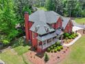 Aerial view of the home showing the roof, landscaping, and a curved driveway approaching a luxury brick home at 6615 Callanwalde Ct, Suwanee, GA 30024
