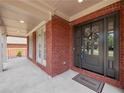 Charming front porch with brick columns, a welcome mat, and a wreath on the front door at 6615 Callanwalde Ct, Suwanee, GA 30024