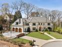 Beautiful home exterior featuring an attached three-car garage, complemented by lush lawn and landscaping at 810 Kenry Ct, Atlanta, GA 30342