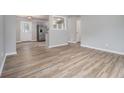 Bright living room with light wood floors, neutral walls, and an open view to the kitchen area at 898 Doeskin Nw Dr, Conyers, GA 30012